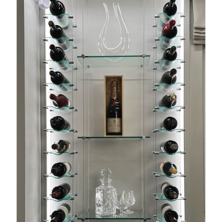 a wine cellar with glass shelves filled with bottles and glasses on top of the shelves