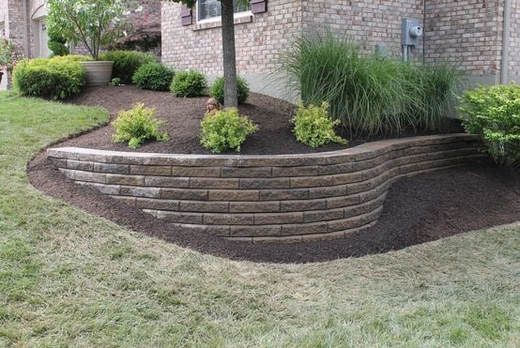 a brick retaining wall in front of a house