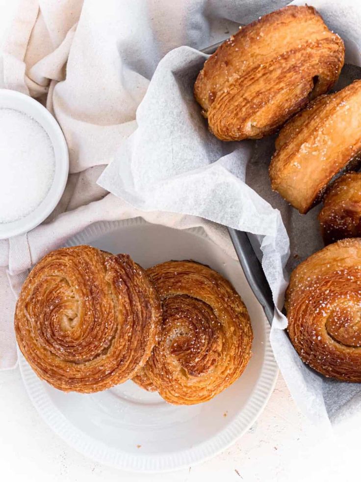 several pastries are on a plate next to a cup and saucer