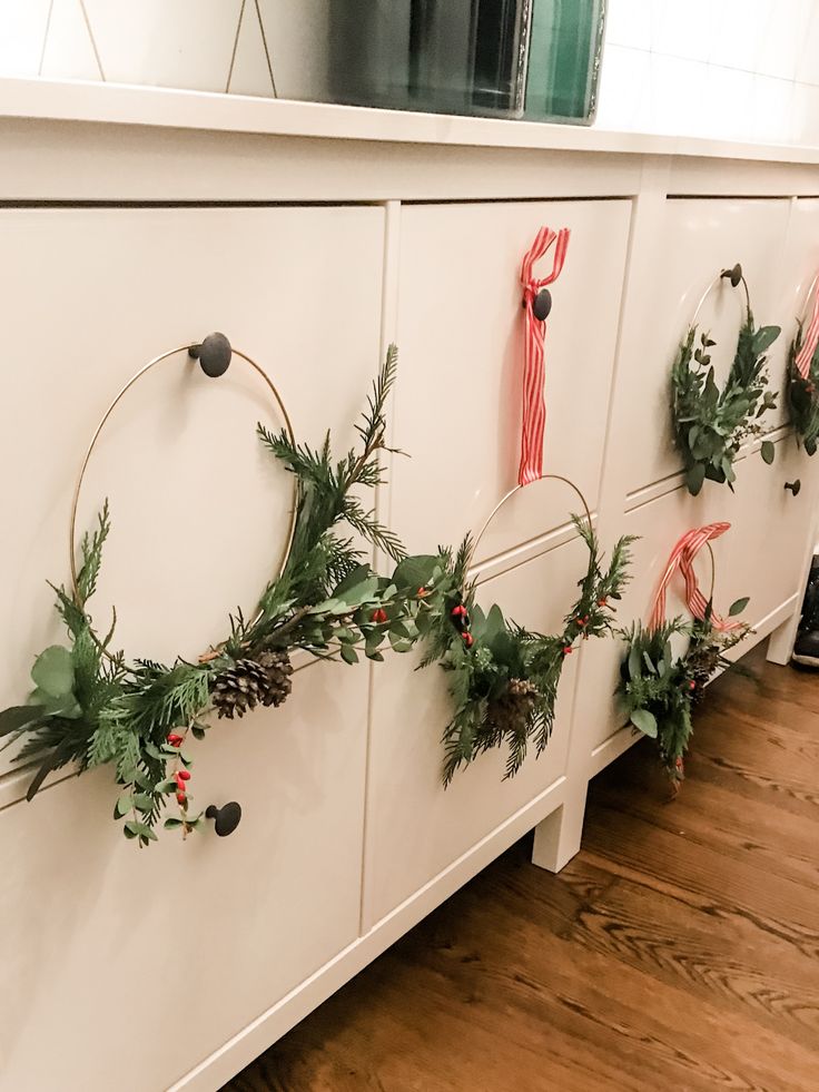 wreaths are hung on the side of a dresser