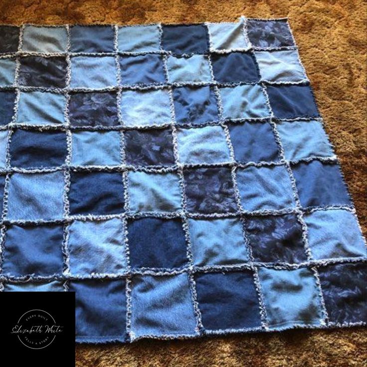 a blue and black quilt sitting on top of a carpet