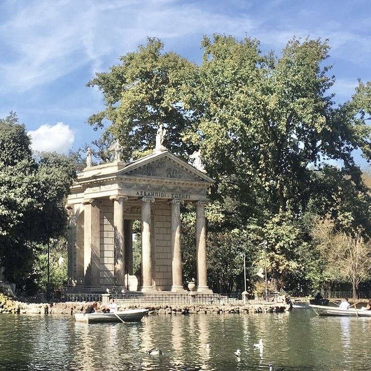 there is a small gazebo in the middle of the water with boats on it