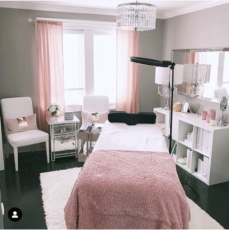 a bedroom decorated in pink and white with a chandelier hanging from the ceiling