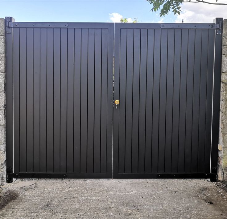 a black gate is open on the side of a building