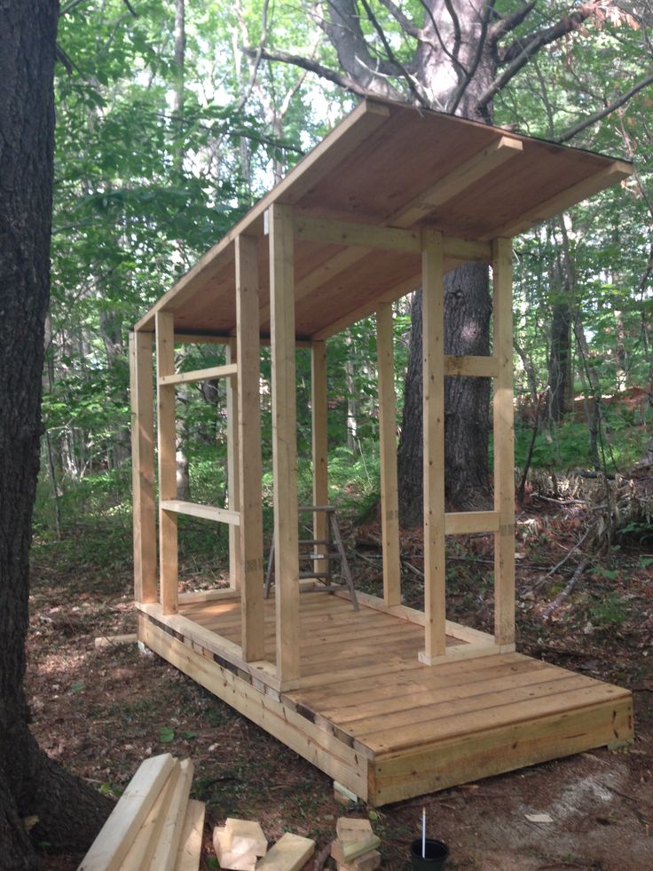 a small wooden structure in the woods