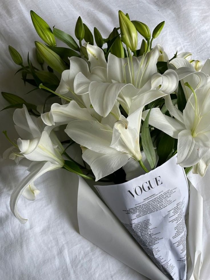 a bouquet of white flowers is wrapped in paper