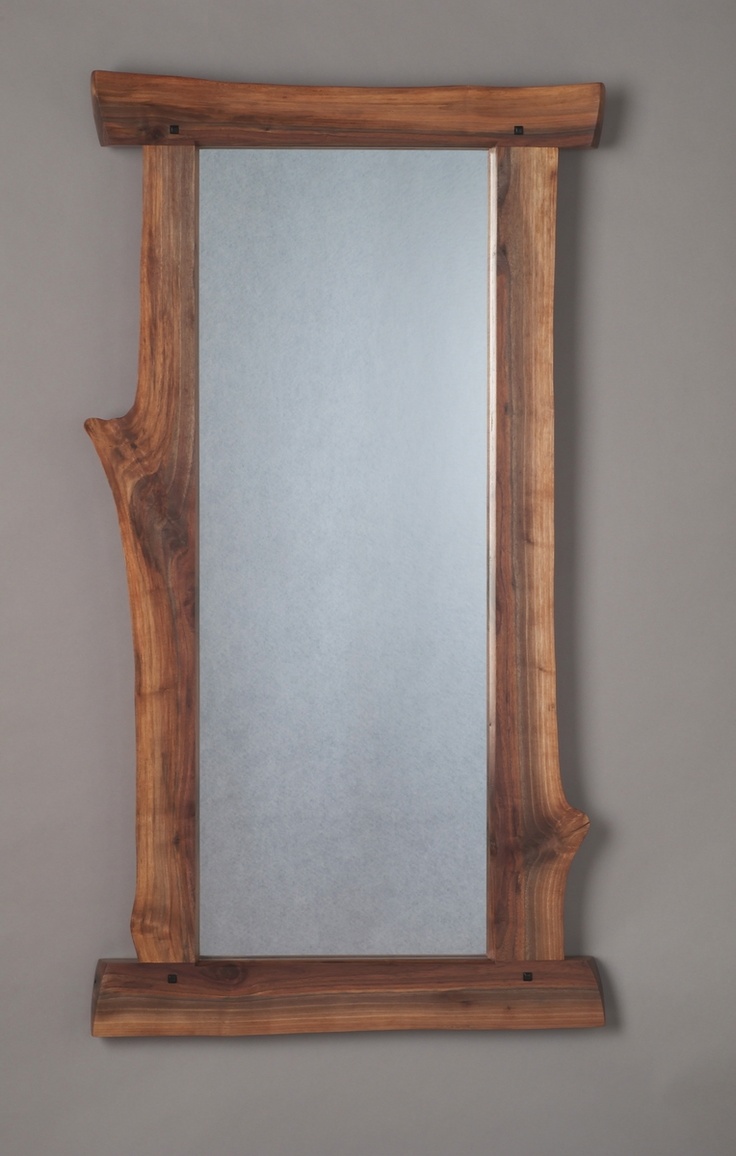 a wooden frame mirror hanging on the wall