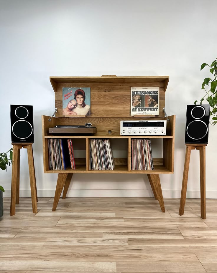 an entertainment center with two speakers and a record player on the shelf next to it