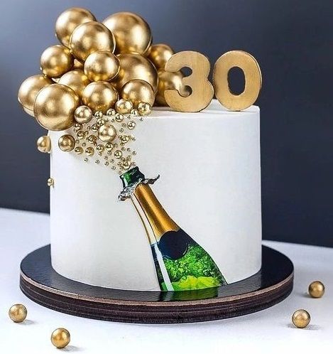 a white cake with gold balloons and a bottle of champagne on the top that says 350