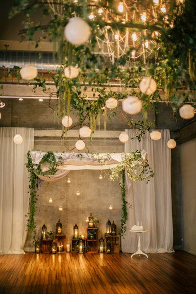 an indoor wedding setup with lanterns and greenery