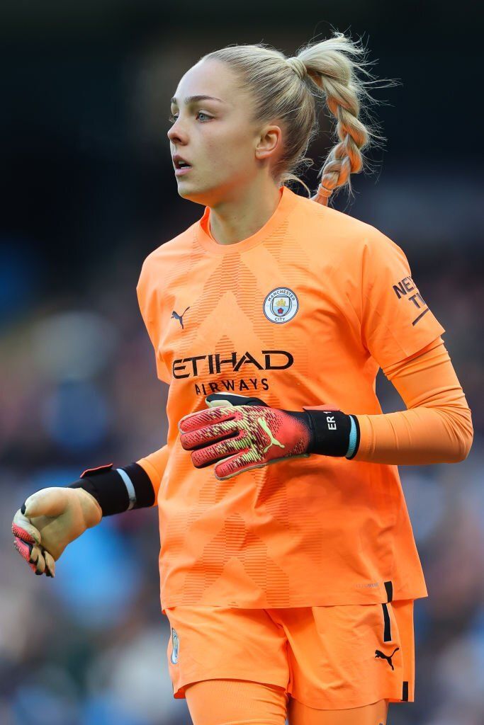 a female soccer player in an orange uniform