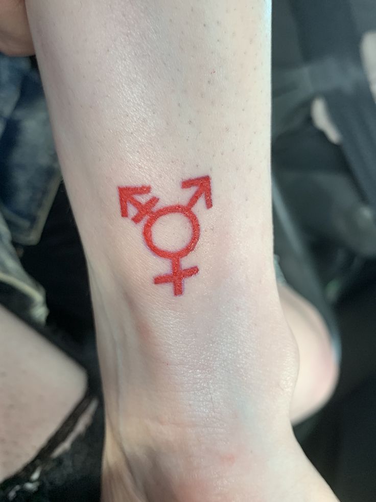 a woman's foot with a red tattoo on it that has an image of the female symbol