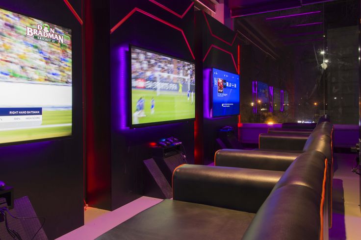 a sports bar with two large televisions on the wall and seats in front of them