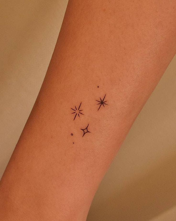 a woman's arm with three small stars on the left side of her body