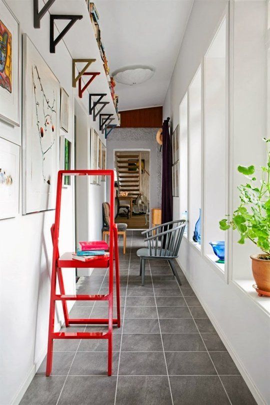 a red ladder sitting on the side of a hallway