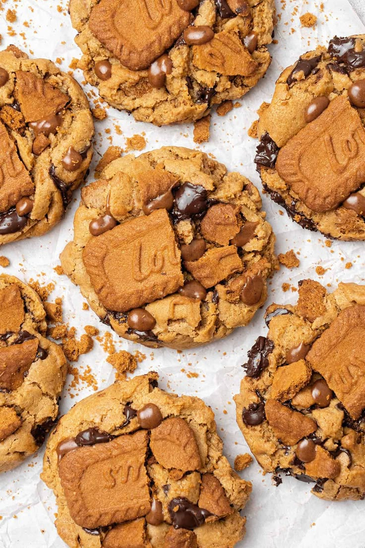 chocolate chip cookies with peanut butter and chocolate chips in the middle, on top of parchment paper