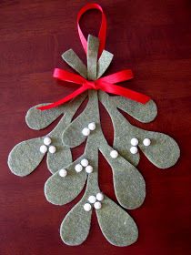 a christmas ornament hanging from a red ribbon on top of a wooden table