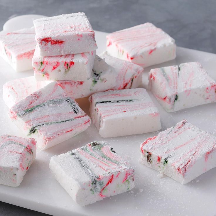 several pieces of cake sitting on top of a white cutting board next to each other