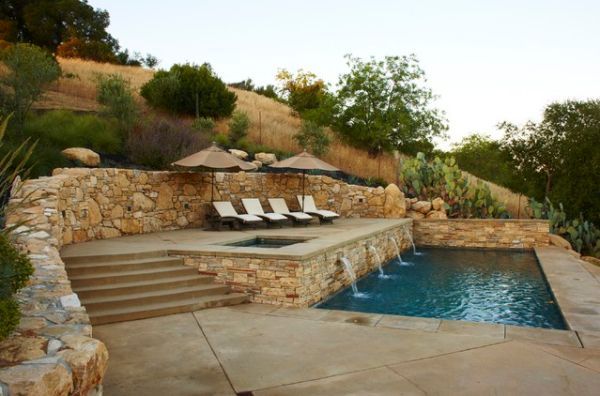 an outdoor swimming pool with lounge chairs and umbrellas