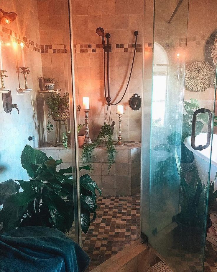 a bathroom with tiled walls and flooring has plants in the shower area, along with a checkered rug on the floor