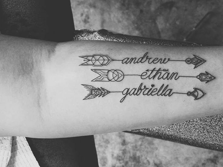 a woman's arm with an arrow and some words tattooed on the side of it