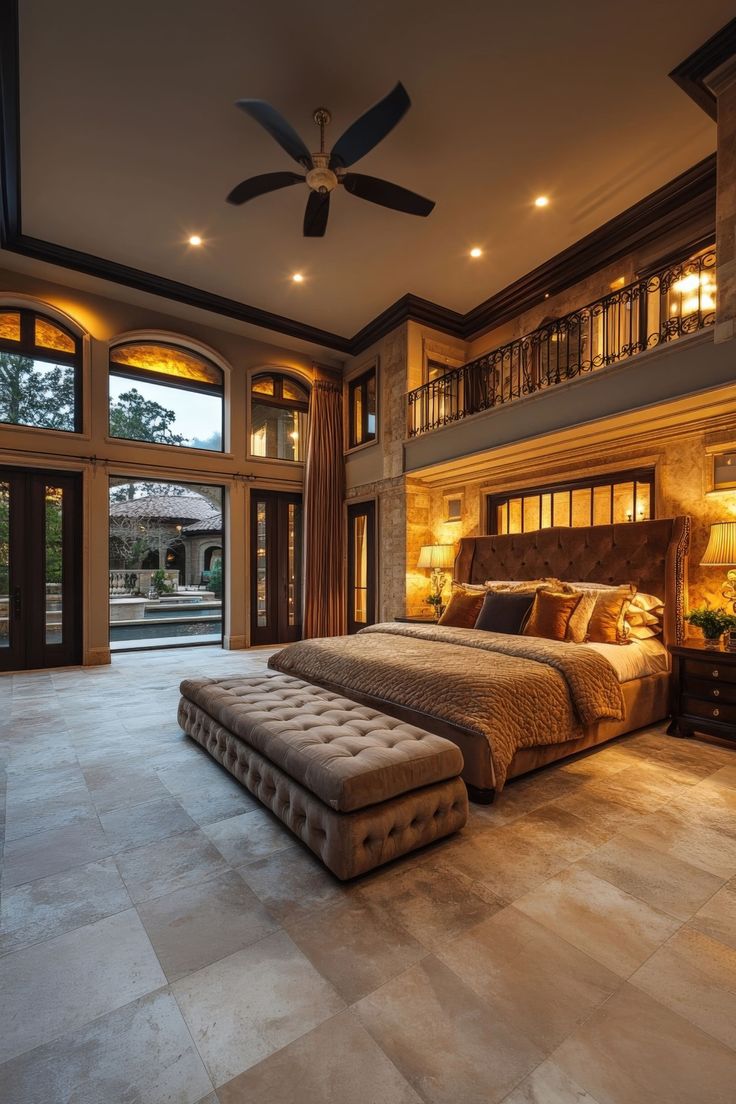 a large bed sitting in the middle of a bedroom next to a window and ceiling fan