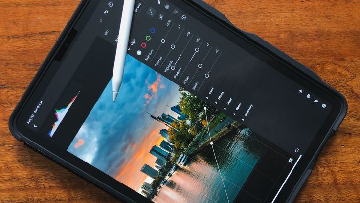 a cell phone sitting on top of a wooden table next to a pen and paper