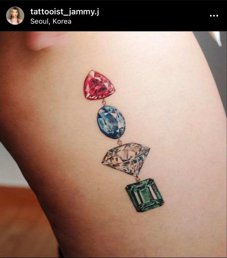 a woman's thigh with three different colored jewels on it