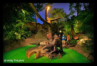 people are looking at dinosaurs in an exhibit