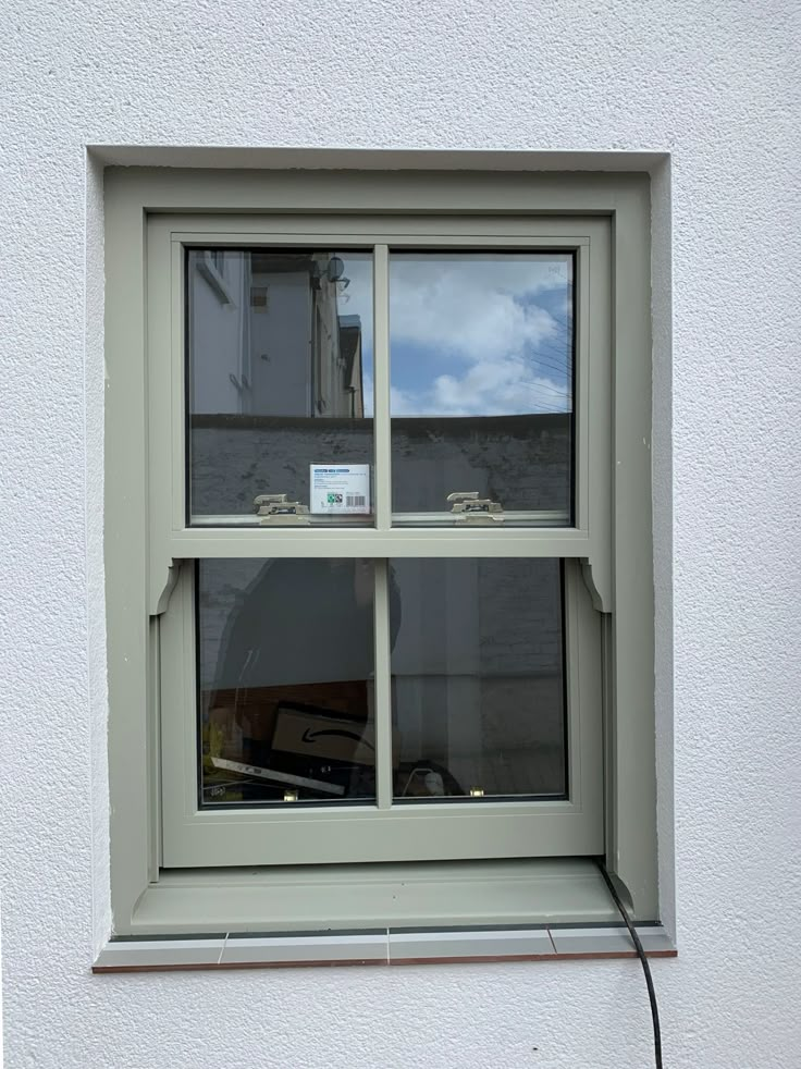 a window that has some kind of sign on it in front of a white wall