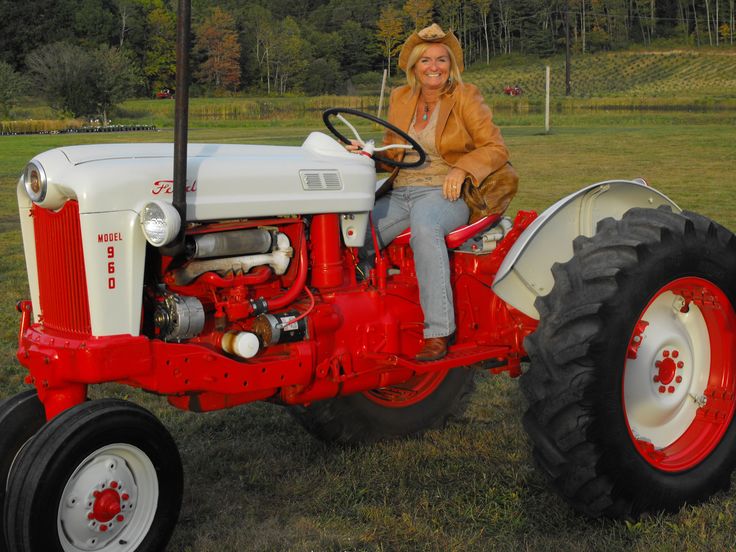 a woman sitting on top of a red and white tractor