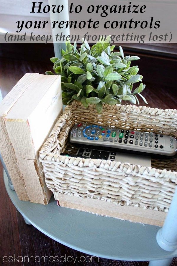 a remote control sitting on top of a table next to a basket filled with plants