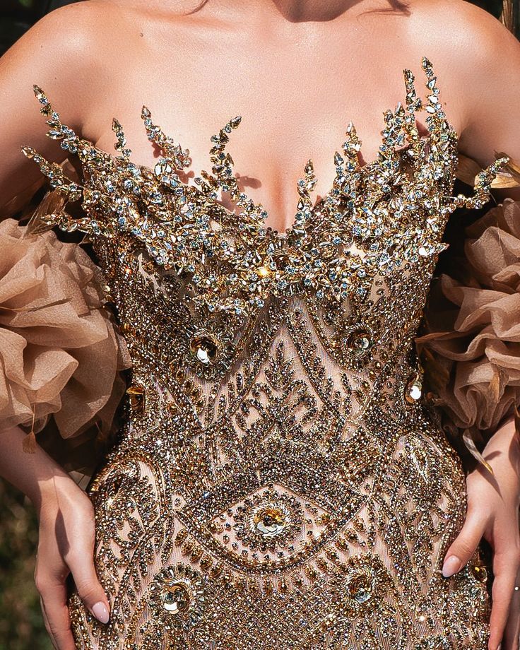 a close up of a woman wearing a gold dress