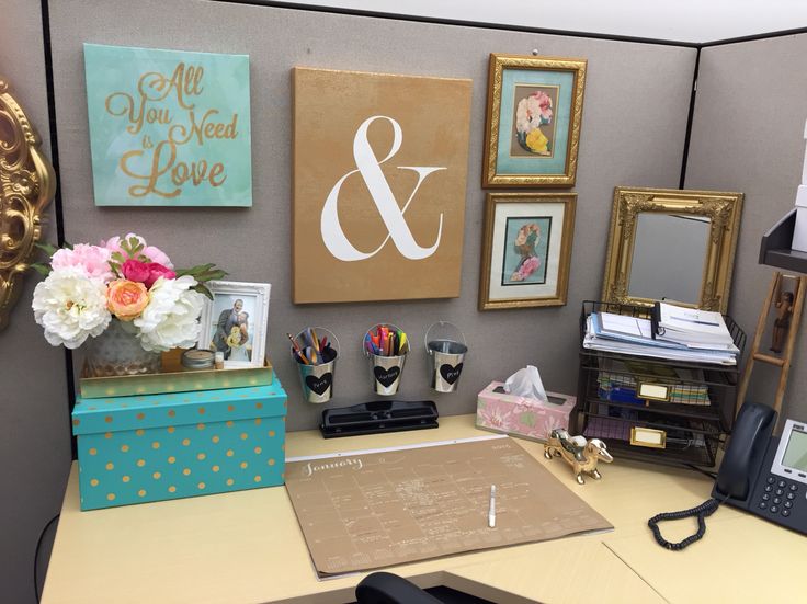 an office cubicle is decorated with pictures, flowers and other items on the desk