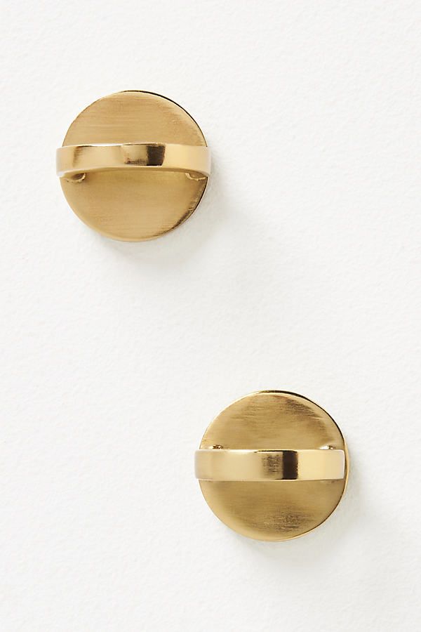 two gold - plated round knobs on white wall, one has a curved handle