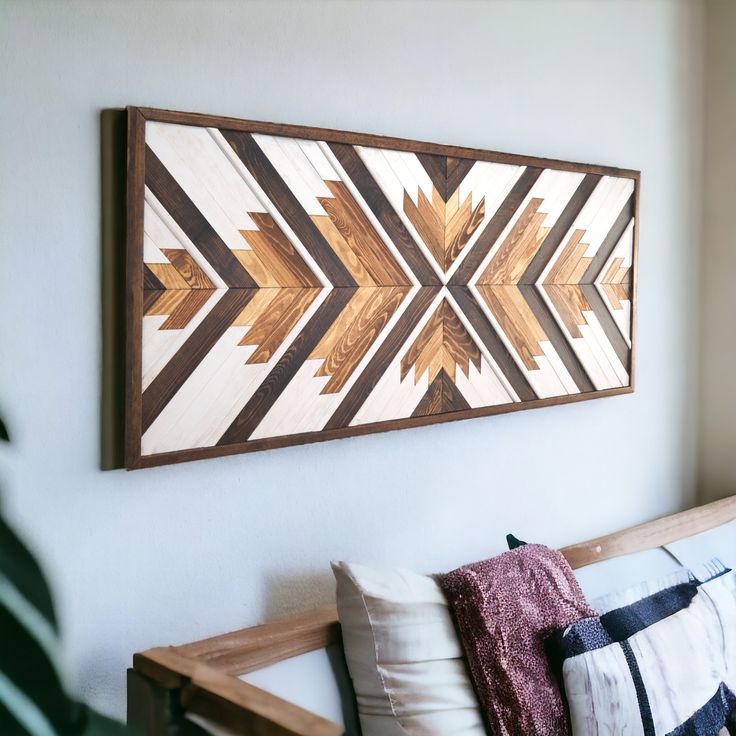 a wooden wall hanging above a bench with pillows