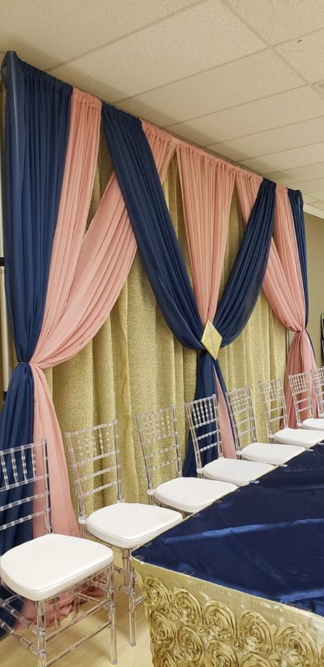 a banquet room set up with blue and pink drapes