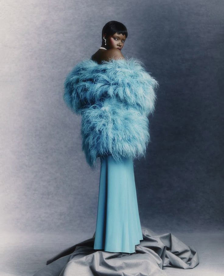 a woman in a blue dress and fur coat