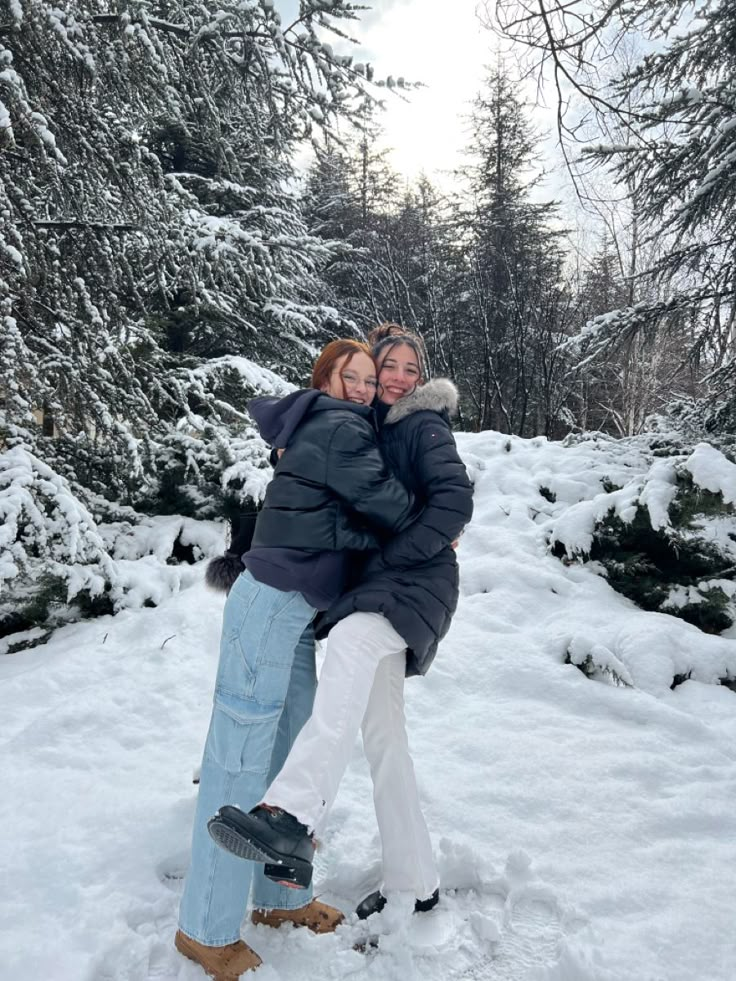 two women hugging each other in the snow