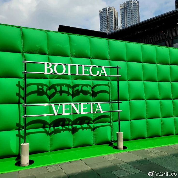 a green wall with the words bottega and veneta written on it