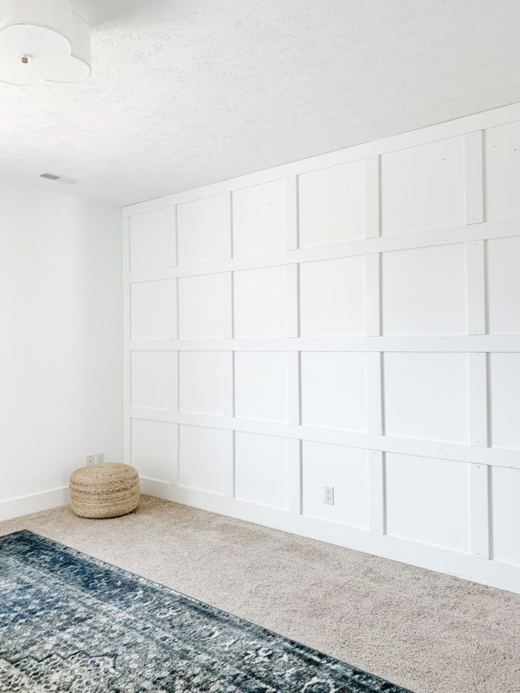 an empty room with white walls and carpet