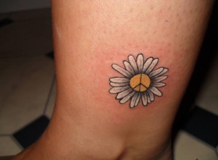 a small daisy tattoo on the ankle