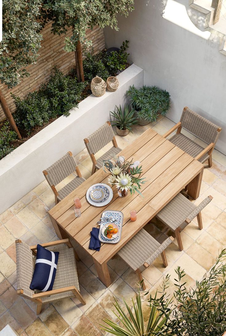 an overhead view of a table and chairs with food on it in the middle of a courtyard