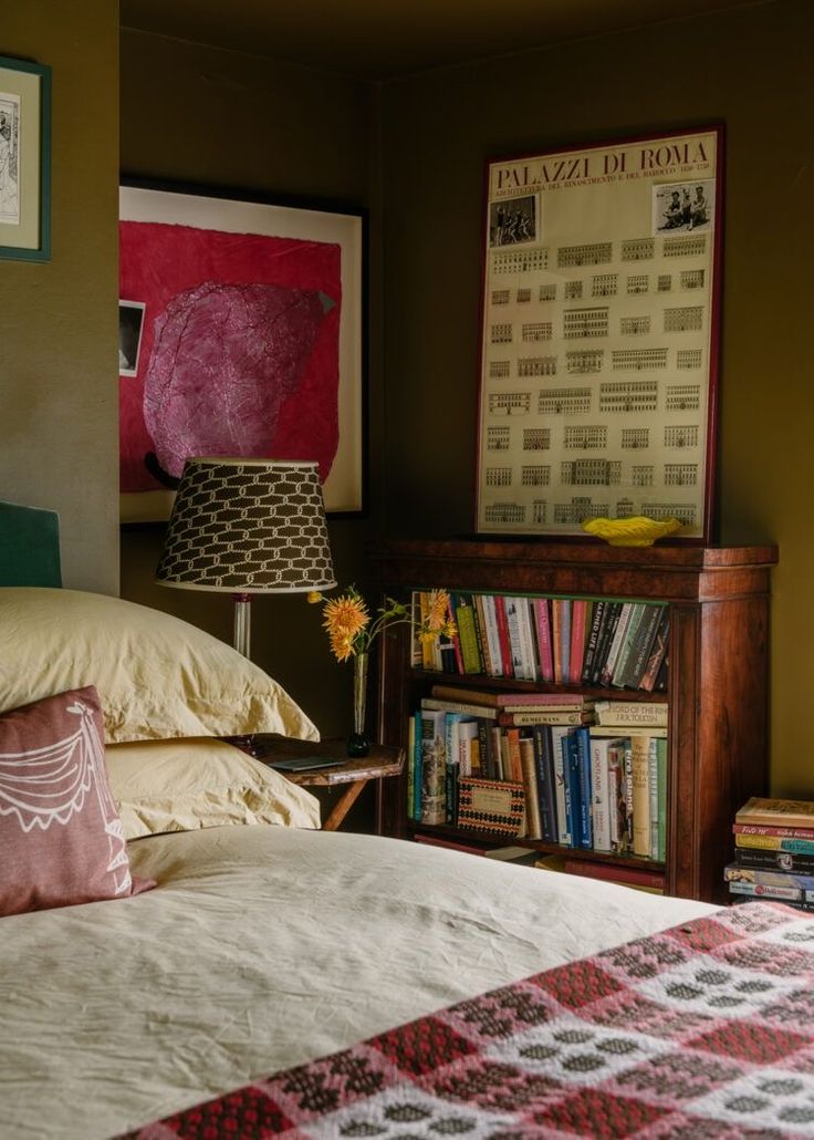 a bedroom with a bed, lamp and bookshelf