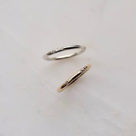 two gold and silver rings with diamonds on them