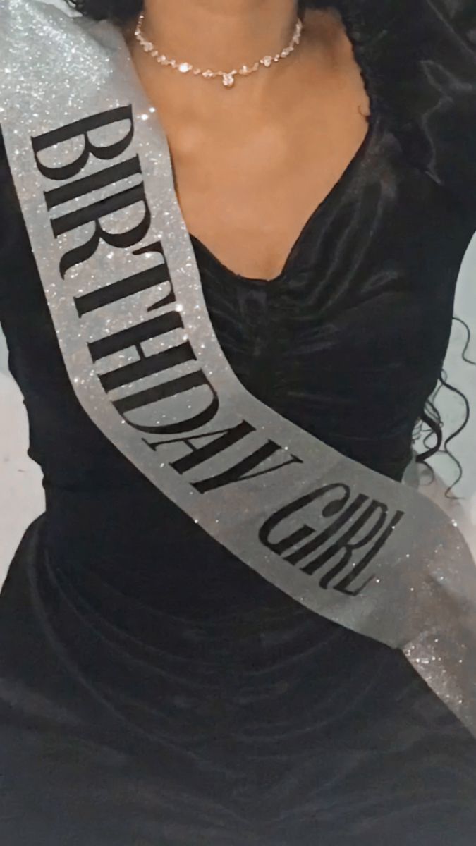 a woman wearing a black dress and holding a silver ribbon with the words brighton on it