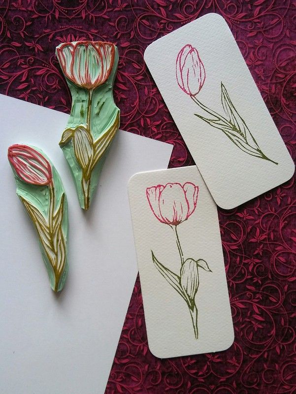 three cards with flowers on them sitting on a table next to some paper and scissors