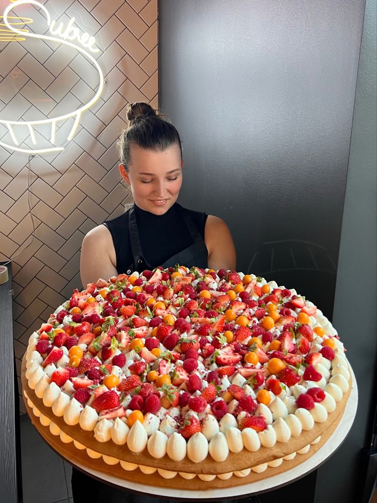 a woman sitting in front of a large cake