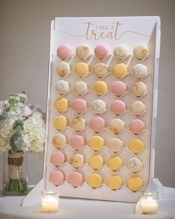 a table topped with lots of desserts next to a vase filled with white flowers