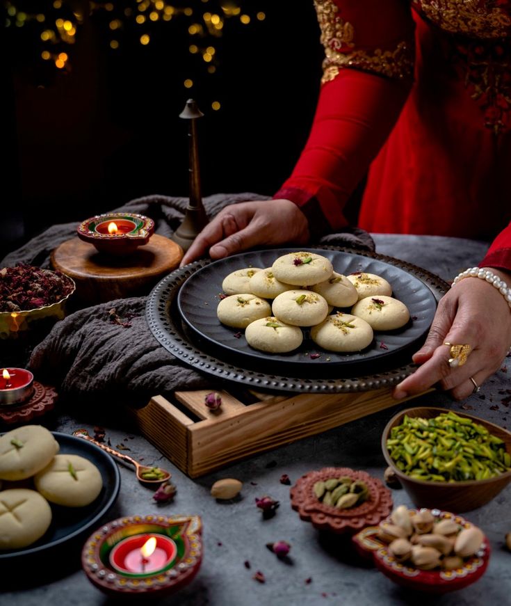 a table topped with plates filled with food next to candles and other foods on top of it